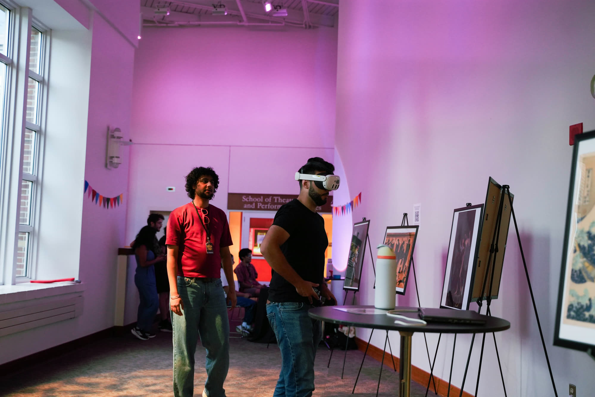 Arindam watches a visitor in a Quest 3 headset move between the easels.